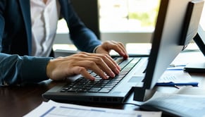 A diligent payroll administrator sits at a sleek modern desk fingers flying across the keyboard as they input data for the upcoming pay period The soft hum of the computer fills the air but the screen remains hidden from view instead the focus is on