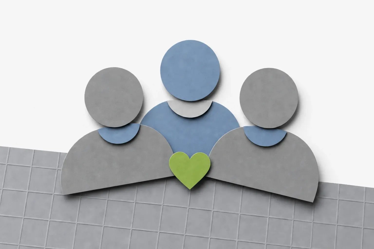 Layered paper team figures on a silver-gray mat